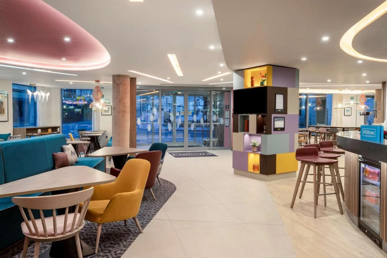 a restaurant with tables and chairs and a bar at Hampton By Hilton Bath City in Bath