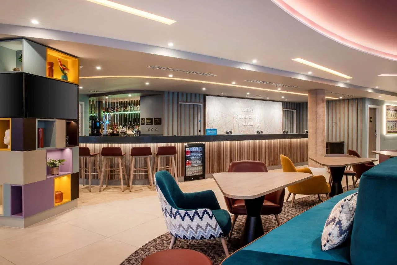 a lobby with a bar and tables and chairs at Hampton By Hilton Bath City in Bath