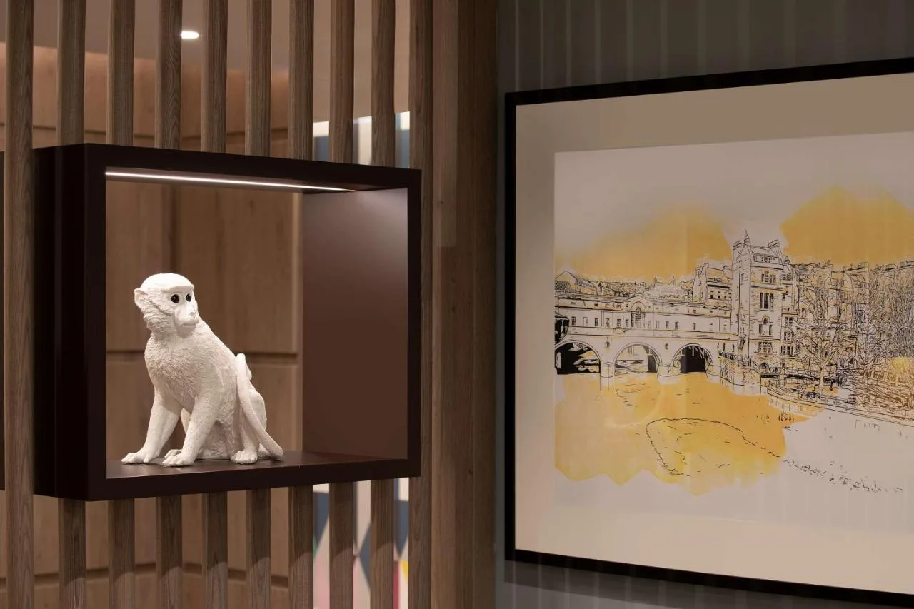 a white cat statue sitting on a shelf next to a picture at Hampton By Hilton Bath City in Bath